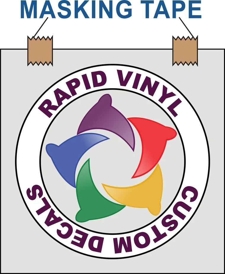 Decal held in position on a surface with small pieces of masking tape at the top corners